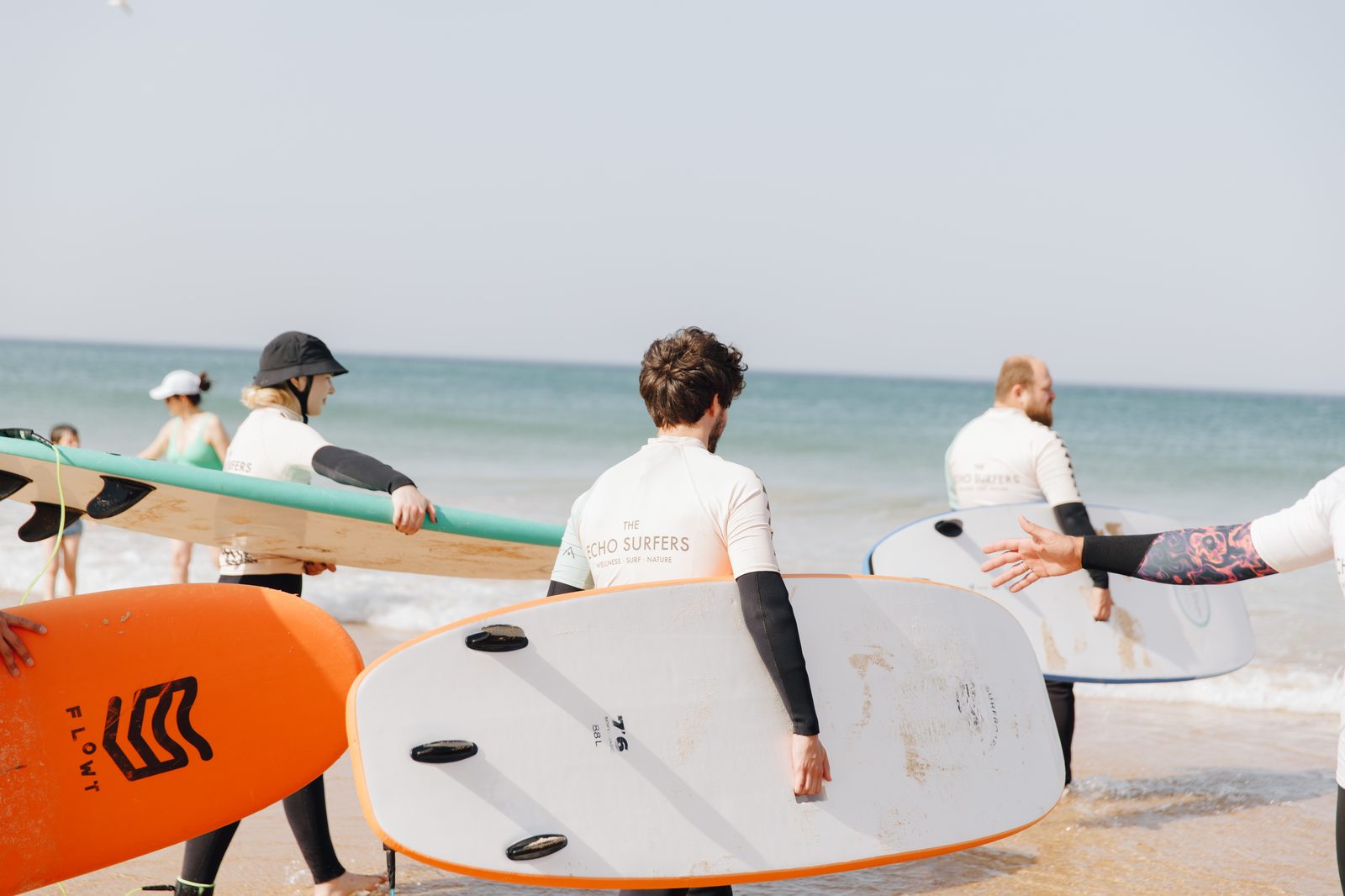 Corporate retreat team surfing activity on the beach in Portugal