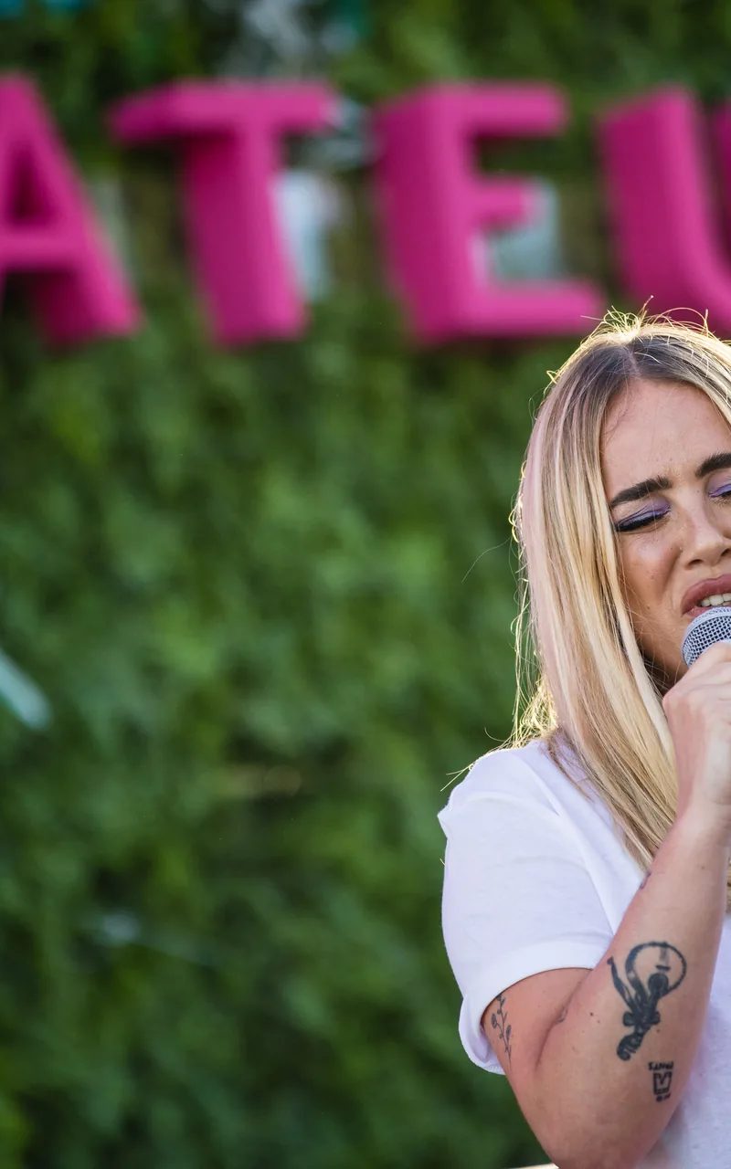 Singer performing at a Mateus brand activation with neon lighting