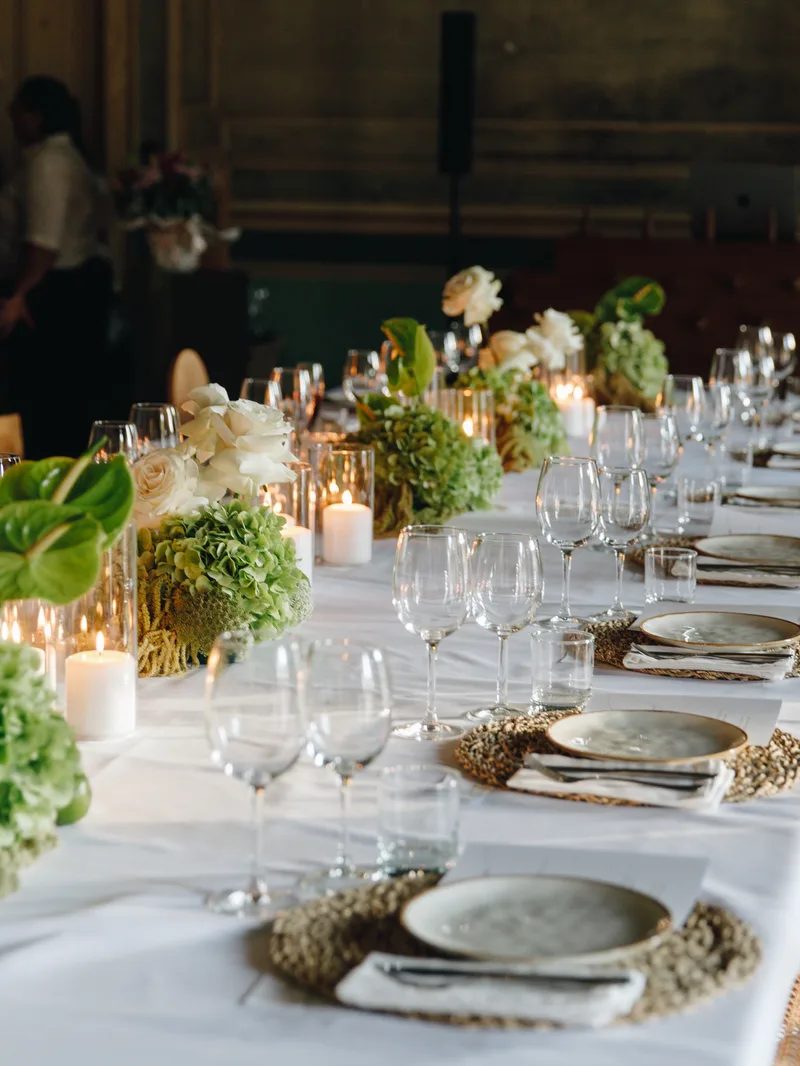 Candlelit table setting at L'Oréal gala dinner with botanical centrepieces